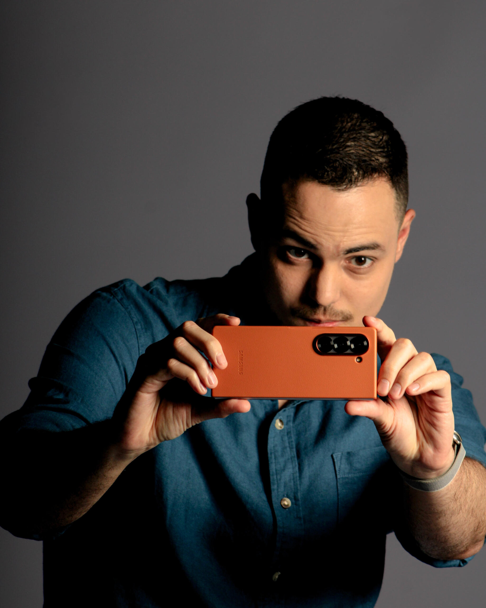Thássius Veloso é apresentador e palestrante Fotografia de homem que observa a tela de um telefone, enquanto tira uma foto
