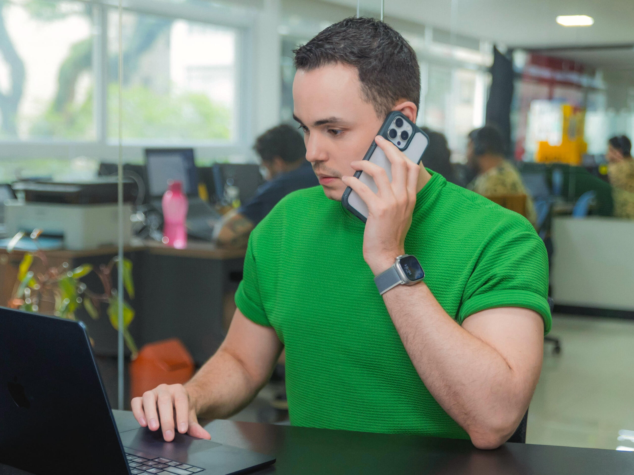 Jornalista Thássius Veloso responde dúvidas de ouvintes da CBN Homem utiliza telefone e computador, em ambiente corporativo